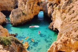 Algarve en famille, vacances petit budget. On aperçoit les eaux turquoises entre des falaises.