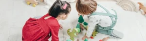 Deux enfants en train de jouer à des jeux en bois sur un tapis.