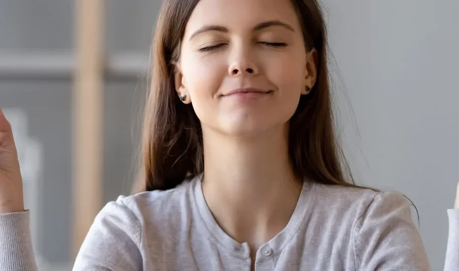 Une jeune étudiante qui fait de la méditation pour repousser le stress et l'anxiété