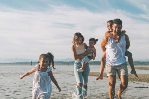 Des parents qui se promènent à la plage avec leurs enfants.