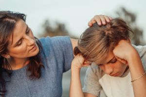 Communication parents-enfants : une mère écoute attentivement son fils qui parait triste.