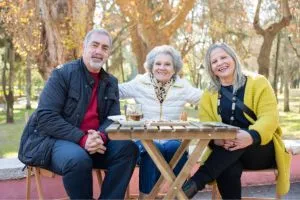 Trois amis seniors qui rigolent autour d'une table.