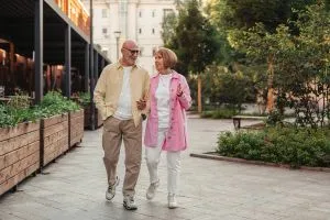 Marcher pour perdre du poids : un couple de seniors qui se baladent dans leur quartier.