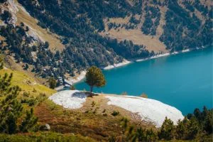 Lac blanc vu d'en haut, pour une randonnée en famille. Le lac est bleu turquoise et entouré de forêt.