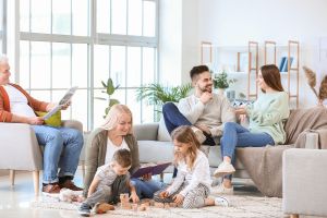 Une famille nombreuse dans un salon qui discute et s'amuse avec les enfants.