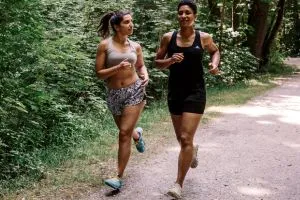 Deux femmes qui courent ensemble dans la forêt pour une bonne santé des os.