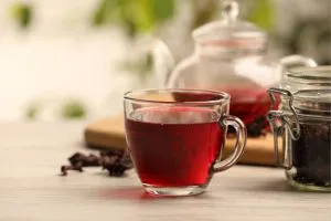 Thé d'hibiscus servi dans une tasse. L'infusion est rouge.