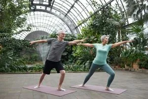 Un couple de seniors qui font du yoga ensemble pour bien vieillir.