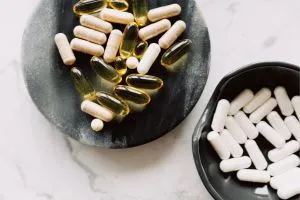 Des gélules et des capsules à base de vitamine D dans des bols sur une table.