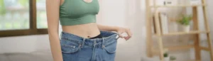 Une femme mince dans un pantalon en jeans trop grand. Elle a réussi à perdre du poids en relançant son métabolisme lent.