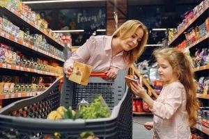Une maman qui fait les courses avec sa fille dans un supermarché.
