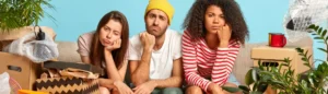 Des étudiants assis sur un canapé entourés de cartons. Ils viennent d'emménager dans leur nouveau logement.