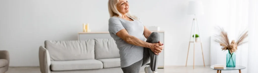 Une femme senior atteinte d'ostéoporose qui fait du sport dans son salon.