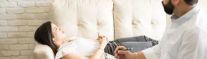 Une femme allongée sur un sofa chez un spécialiste pour reprogrammer son subconscient.