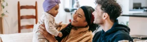 Des jeunes parents qui portent leur bébé dans les bras et profite du congé parental.