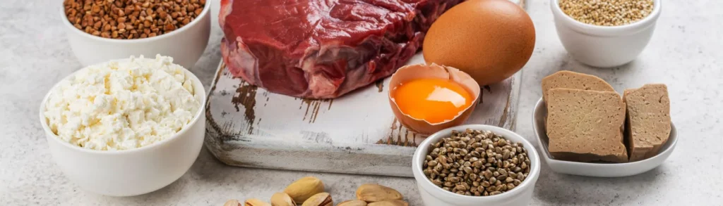 Des aliments riches en fer (viande rouge, œuf, lentilles, pistaches) sur une table.