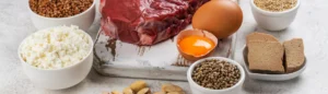 Des aliments riches en fer (viande rouge, œuf, lentilles, pistaches) sur une table.