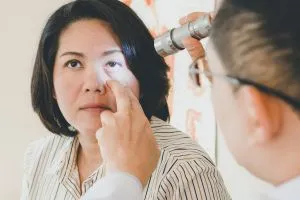 Un ophtalmologue ausculte l'œil d'une patiente pour contrôler un glaucome.