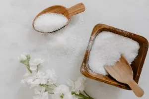 Sel (riche en sodium) sur une table en marbre. Dans un récipient en bois et une cuillère en bois.