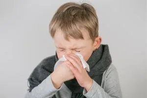 Un enfant se mouche, il semble malade car il a un problème d'immunité à la rentrée scolaire.