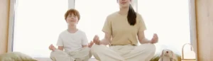 Une maman et son fils font une routine bien-être en pratiquant des exercices de yoga ensemble.