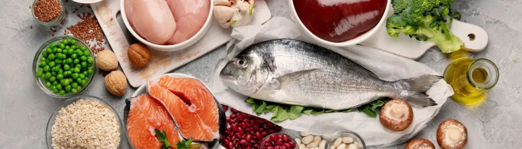 Des aliments riches en sélénium sur une table (poisson, viande, noix, pois, amandes, graines, etc.)