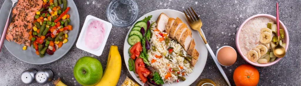 Menu sans gluten : des plats à base de viande, légumes et fruits sur un plan de travail.