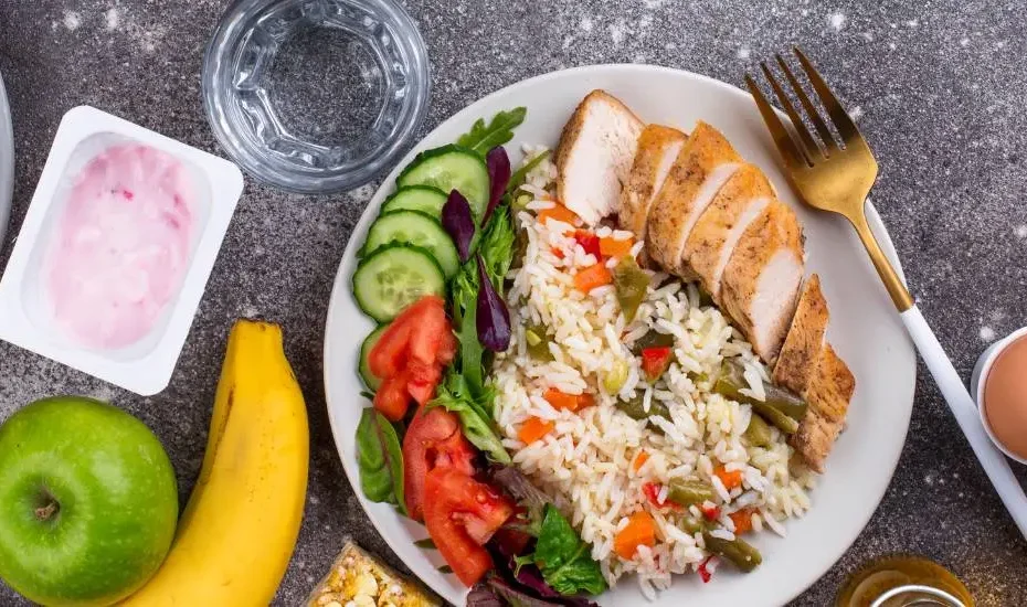 Menu sans gluten : des plats à base de viande, légumes et fruits sur un plan de travail.