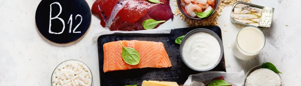 Des aliments riches en vitamine B12 disposés sur une table : saumon, foie de bœuf, œuf, fromage, etc.