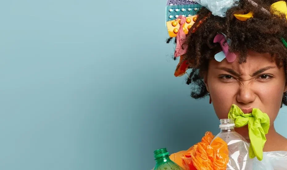 Une femme avec des plastiques sur le corps qui représentent les perturbateurs endocriniens du quotidien (eau en bouteille, jouets, médicaments, cosmétiques, etc.)