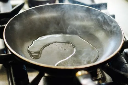 Poêle en téflon (PFAS) avec de l'huile qui brûle.