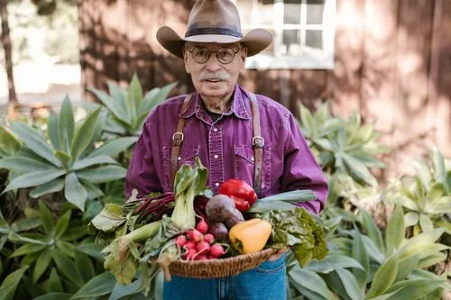 Un jardinier qui montre fièrement sa récolte de légumes bio.