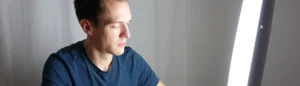 Un homme qui utilise la luminothérapie dans son salon.
