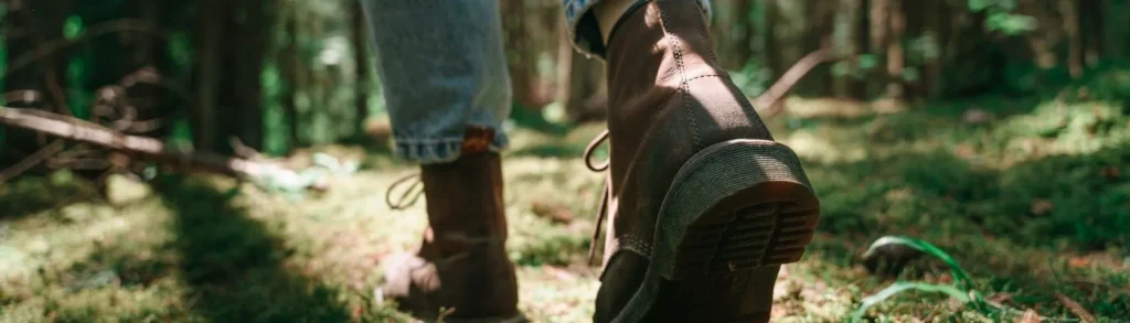 Une femme qui se balade en pleine nature pour profiter des bienfaits de la forêt.