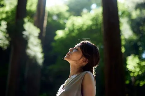Une femme apaisée dans la forêt.