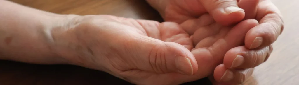 Des mains posées sur une table avec des fourmillements.