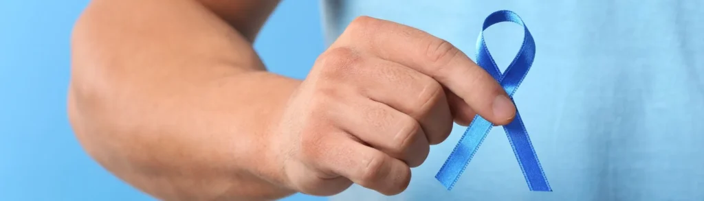 Un bras d'homme qui tient un ruban bleu en main en signe de cancer de la prostate.