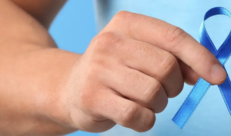 Un bras d'homme qui tient un ruban bleu en main en signe de cancer de la prostate.