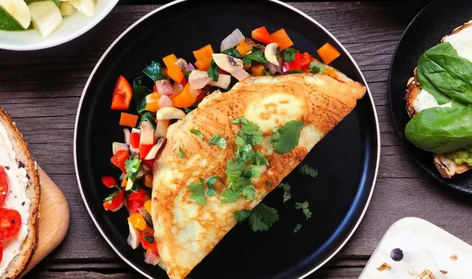 Photos de plats pour un menu régime hyperprotéiné. On aperçoit une omelette au poulet et aux légumes, des tartines, etc. sur une table.