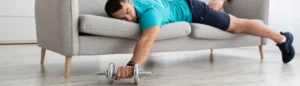 Un homme couché sur un canapé avec un haltère en main, en signe de récupération musculaire.