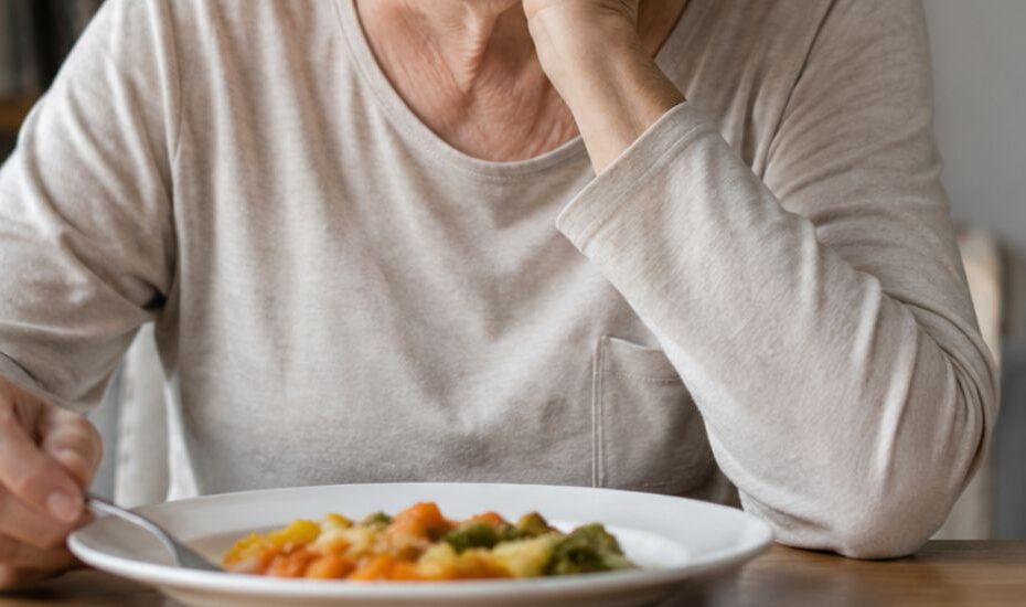 Une personne âgée qui ne mange plus, elle regarde son assiette pleine sans appétit.